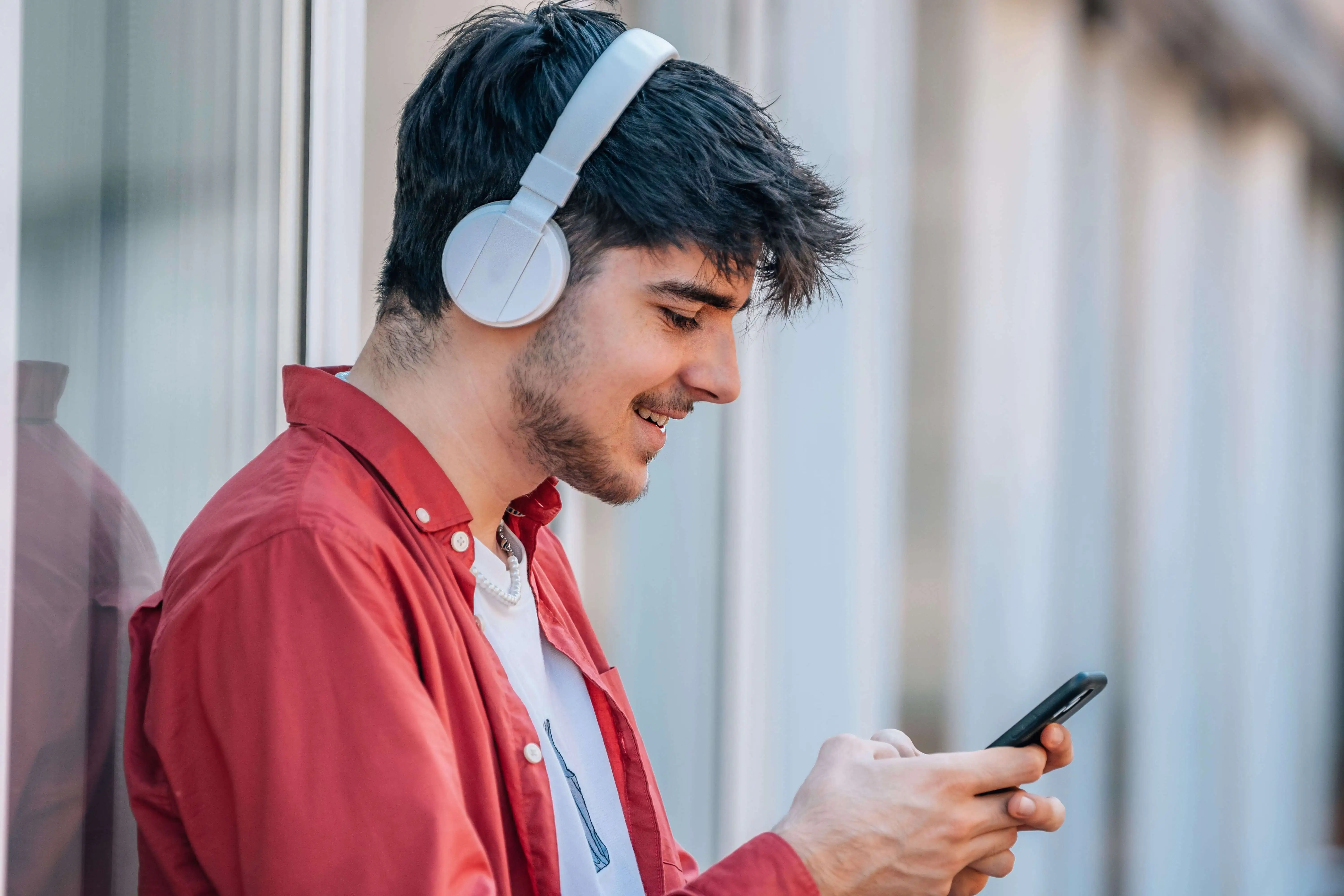 Jeune homme écoutant un podcast avec son casque audio