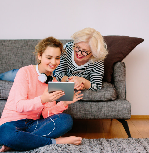 Mère et fille concentrées sur une tablette connectée en adsl