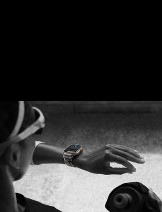 Une personne qui court regarde une Apple Watch Ultra 2 à son poignet gauche et effectue le geste toucher deux fois avec l’index et le pouce de sa main gauche
