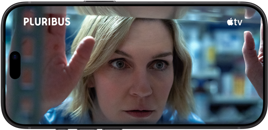 iPhone 18                                                                Pro, mode paysage, affichant un gros plan d’une femme                                                                regardant à travers une étagère. Nom de la série :                                                                Pluribus