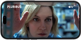 iPhone 18                                                                Pro, mode paysage, affichant un gros plan d’une femme                                                                regardant à travers une étagère. Nom de la série :                                                                Pluribus
