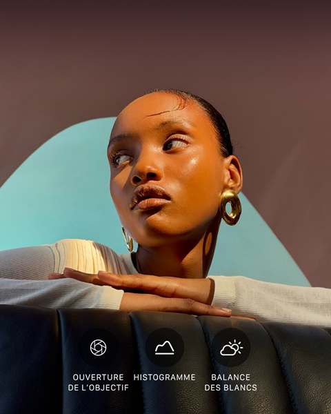 Portrait lumineux en gros plan d’une                                                                personne sur un fond coloré, illustrant l’interface des                                                                commandes Pro du système caméra pro : ouverture,                                                                histogramme, balance des blancs