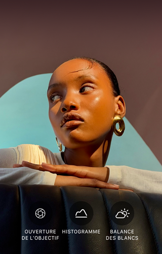 Portrait lumineux en gros plan d’une personne sur                                                                un fond coloré, illustrant l’interface des commandes Pro                                                                du système caméra pro : ouverture, histogramme, balance                                                                des blancs