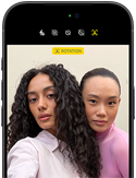 iPhone 18 Pro,                                                                                    noir, face avant, affichant deux                                                                                    modèles qui posent pour la caméra,                                                                                    mettant en avant la caméra avant                                                                                    Center Stage